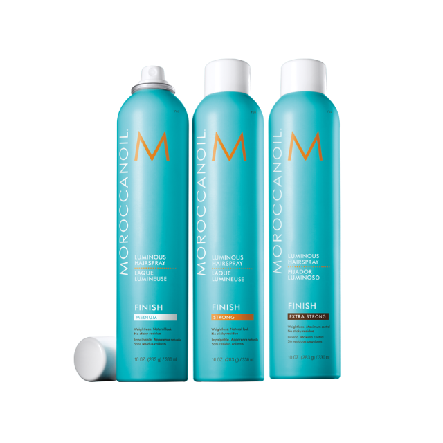 Three bottles of Moroccanoil hair spray on a white background